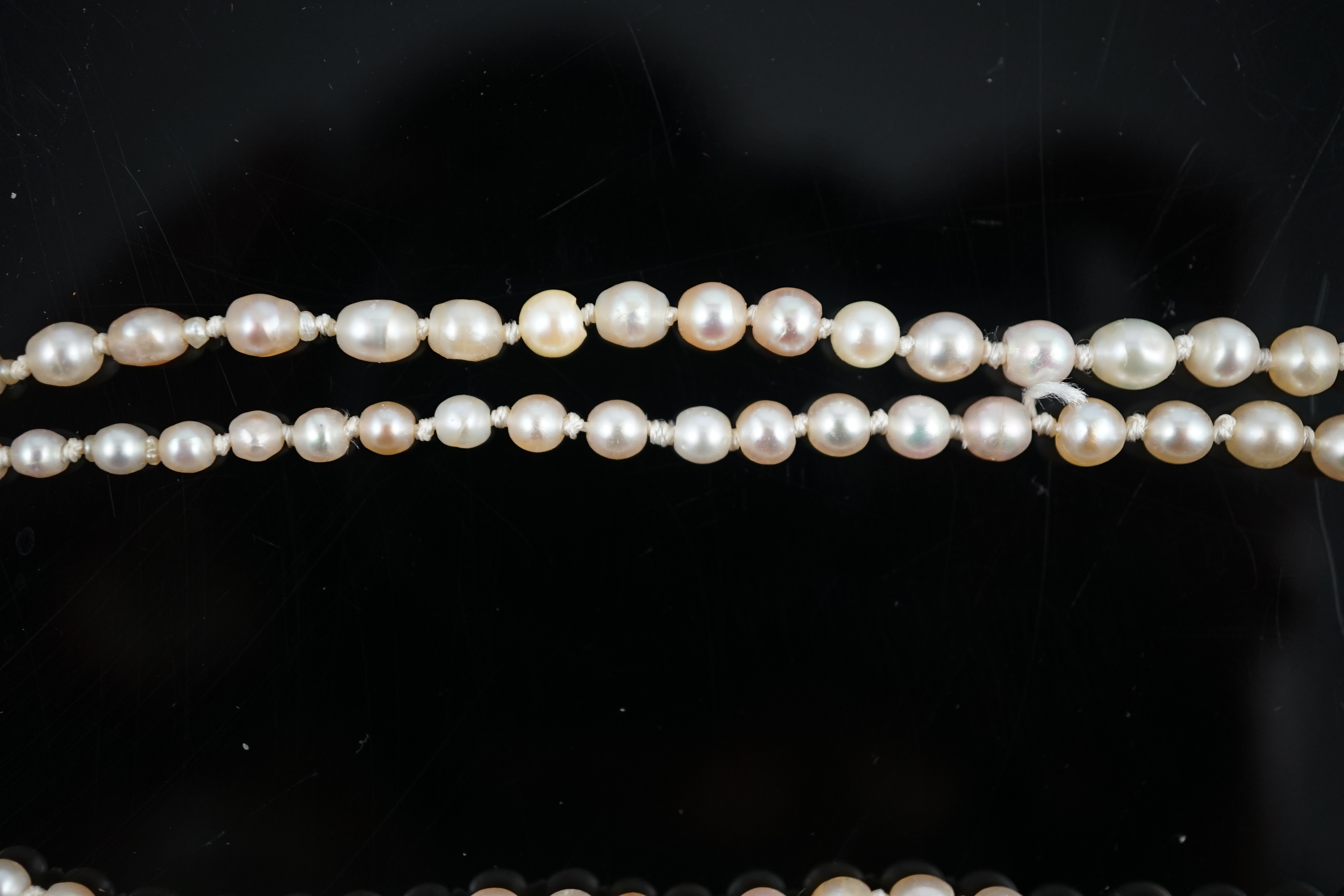 A twin strand graduated cultured pearl necklace, with gold and six stone diamond set rectangular clasp